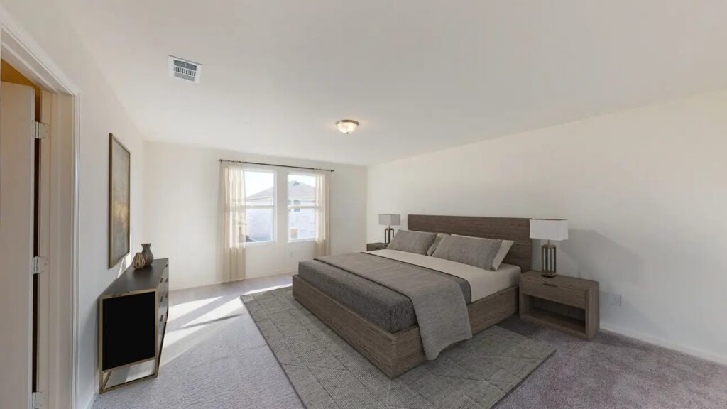 Open-concept living room with soft neutral walls, large windows, and easy flow into the kitchen.